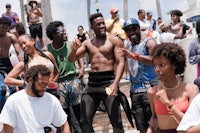 a group of people dancing on a beach in california